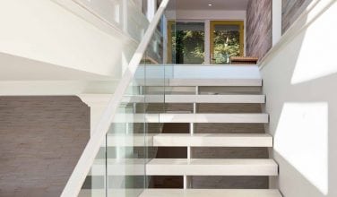 Glass-enclosed floating staircase with 3″ white oak treads
