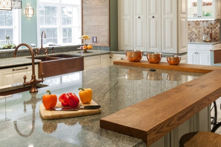 green granite counter top with second tier of stained wood over green painted custom cabinets