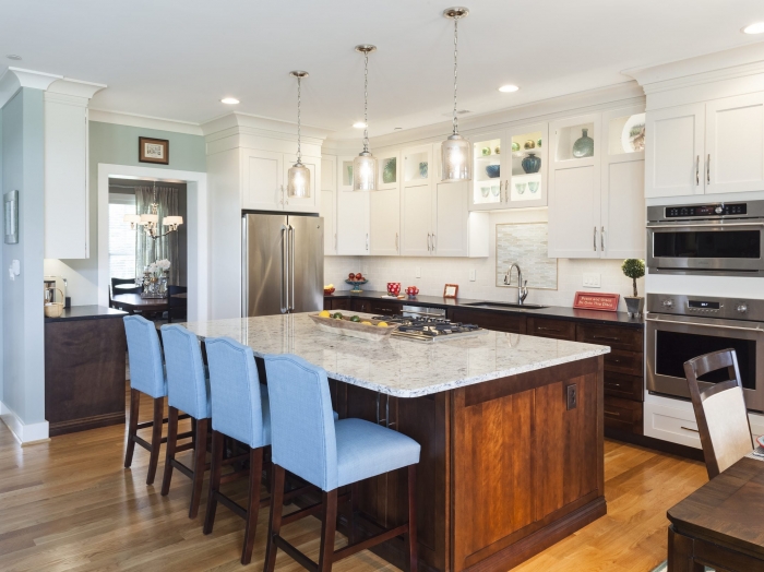 two tone white upper kitchen cabinets and stained wood lower with white granite top island and leather black granite perimeter counter top