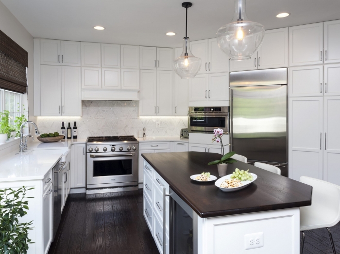 kitchen with white shaker style cabinets, dark wood floors, mahogany wood island top, ornate white backsplash