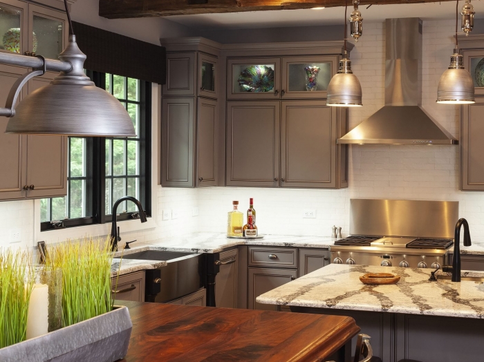 rustic kitchen with gray cabinets, wood top island and zebra veined engineered stone, wood ceiling beams
