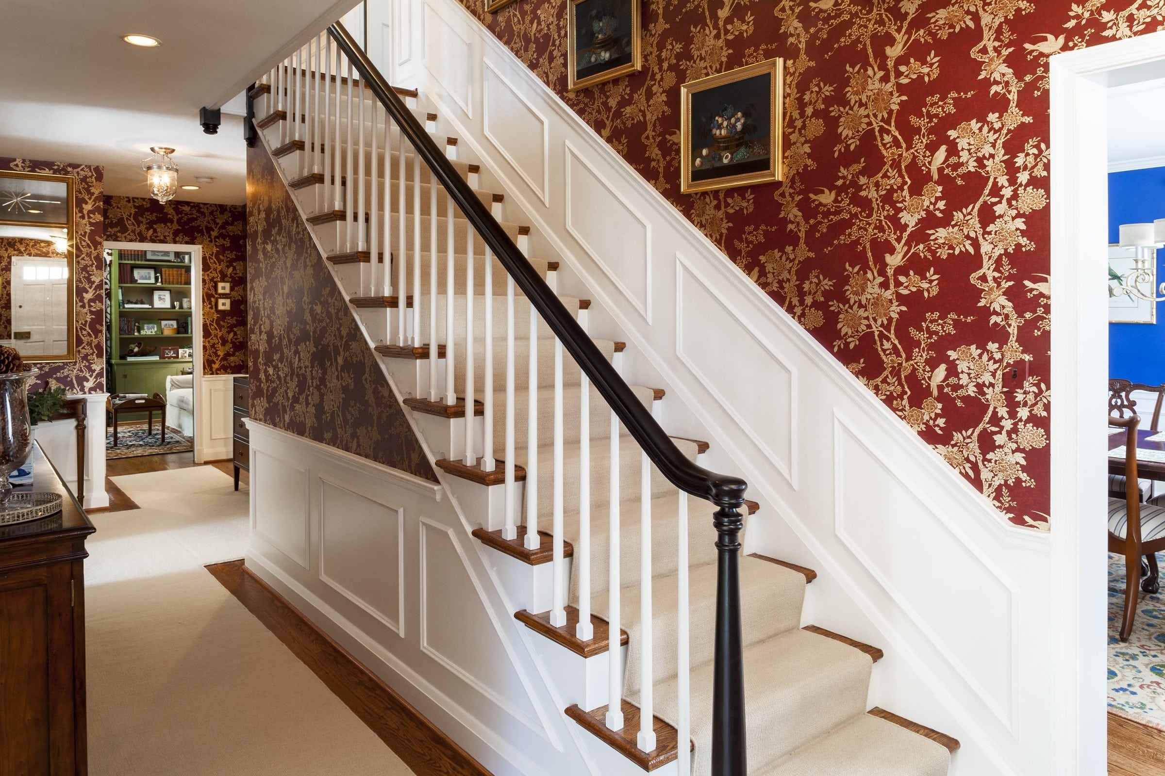 remodeled home interior with luxurious staircase and ornate red wallpaper