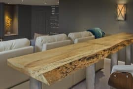 Basement with sculptures, couch, and natural wood bar