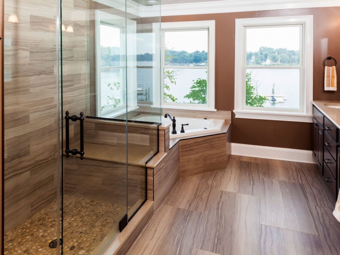 Waterfront master suite with corner tub, pebble floor shower, and double vanity