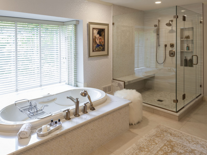 luxury bathroom with light wood cabinetry, vanity table, tile floor, flocked wallpaper, tub and walk in shower