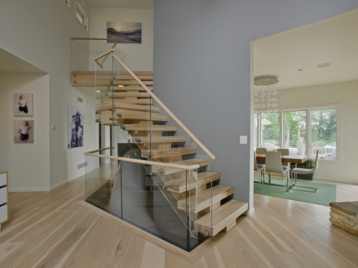modern floating staircase with natural wood steps, glass stair rail with stainless hardware