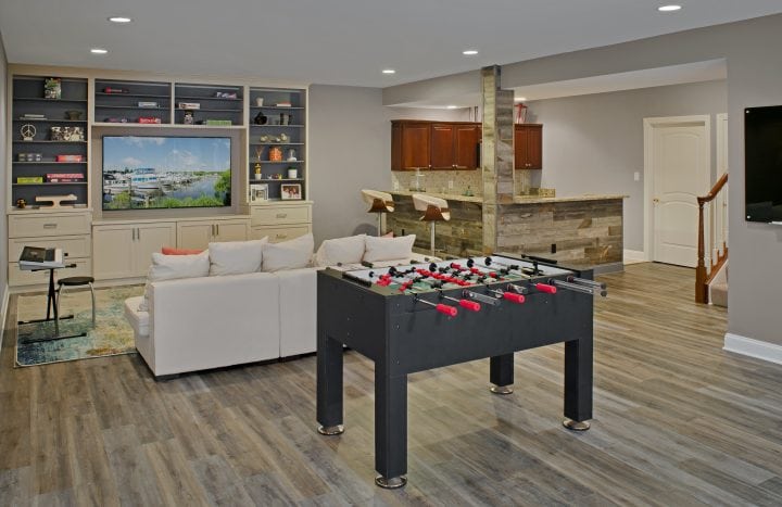 remodeled basement with foosball table, entertainment center, and bar