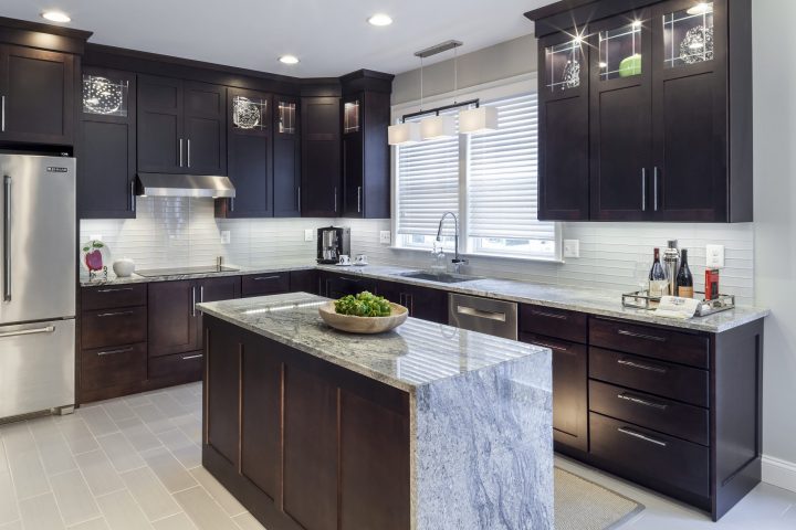 transitional stained wood kitchen island with waterfall granite top