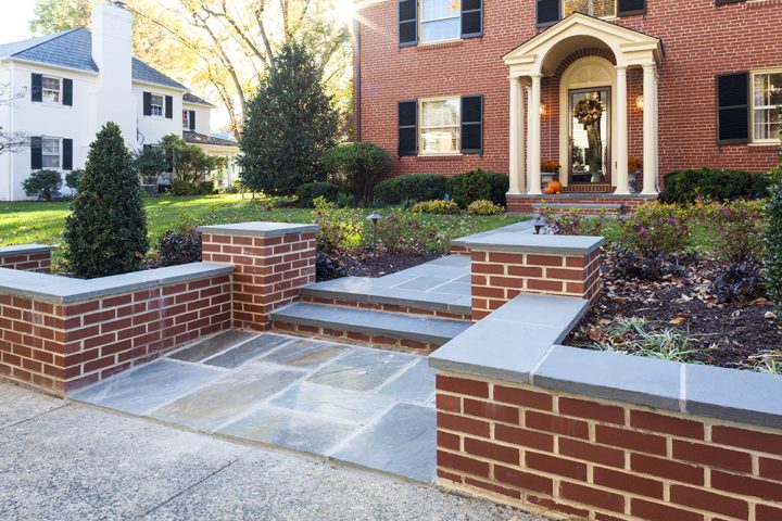 traditional entry door to brick home with blue stone walk