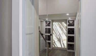 sunken wine room with full length double glass doors that lock for protection of the children