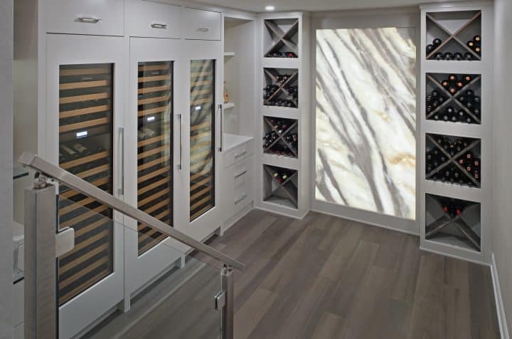 wine room with marble lighted wall panels and glass doors that lock for protection of children