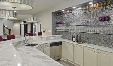 Lighted marble bar top and serving counter add to the beauty of this extraordinary entertaining space connected to the wine room