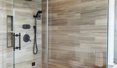 maculine master bath shower with built in bench and glass panels