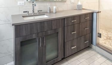 contemporary vanity in gray with glass doors and square sink