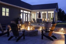 built in permanent fire pit on round patio with seated walls