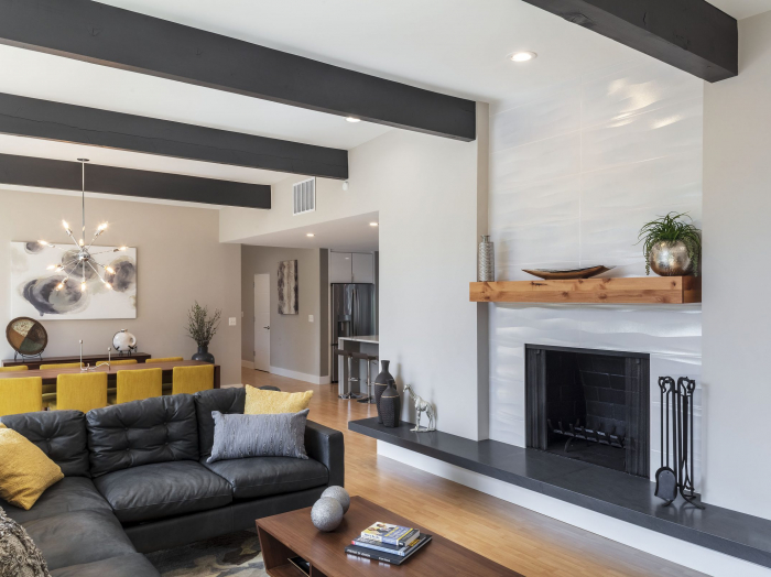 white wave ceramic tile fireplace and rustic wood beams