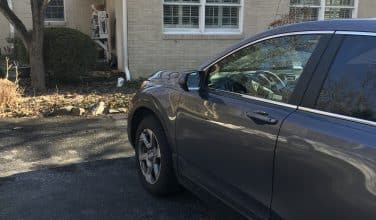 car in driveway before garage