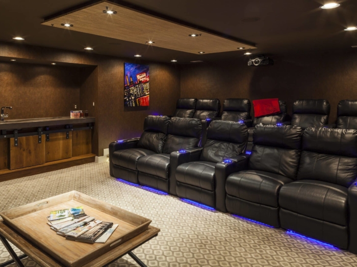 luxurious home movie theater with projector and light-up recliners