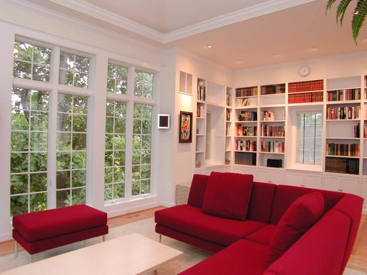 sunroom with large windows, white walls, red couches