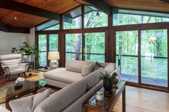 wall of windows, treed landscape, wrap around deck, modern interior renovation