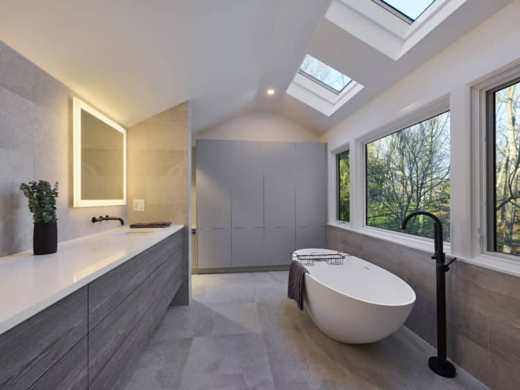 soft gray tile and wood primary bathroom with soaking tub