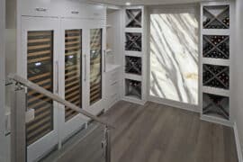 wine room with lighted wall and wine coolers and shelving
